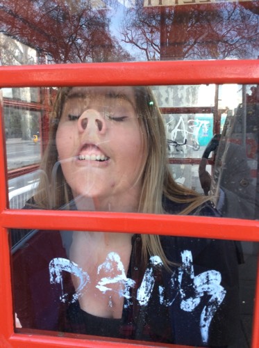 A participant enjoying a team building game from Cluego in a telephone box in London