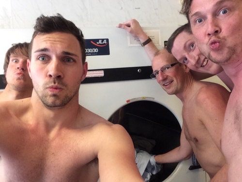 A topless team taking a selfie in a laundretter for a Cluego treasure hunt