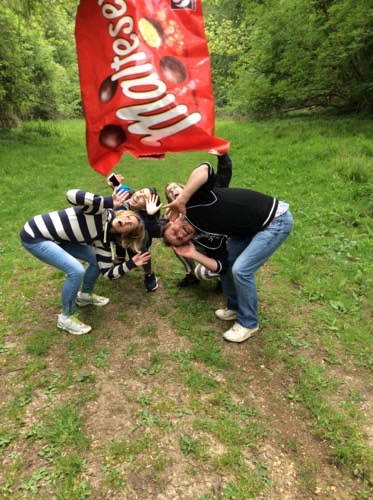 A team taking a picture with a packet of Maltesers for a Cluego team game challenge